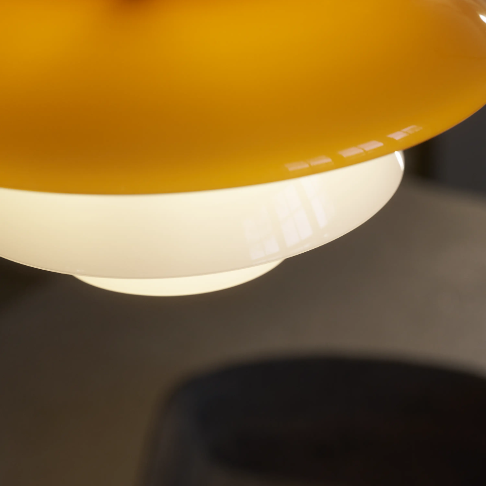 A close up of the amber colored top shade of the PH 3/3 Pendant Centenary Edition by Louis Poulsen.
