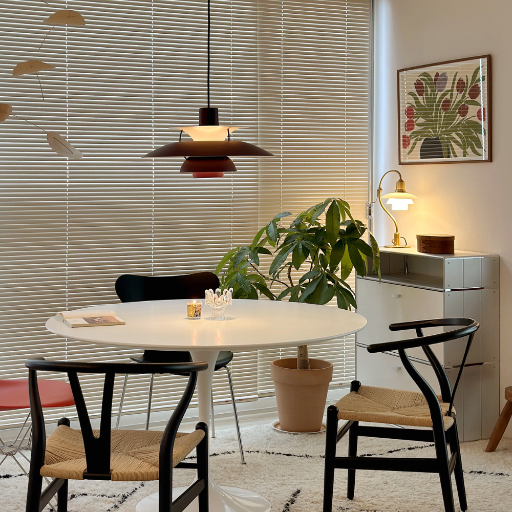 The PH 5 from Louis Poulsen in monochrome burgundy in a dining room.