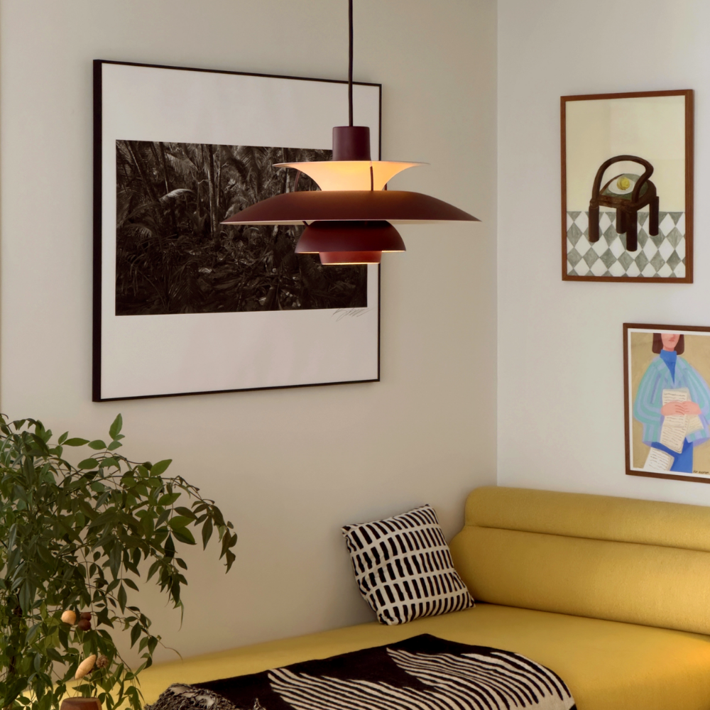 The PH 5 from Louis Poulsen in monochrome burgundy in a living room.