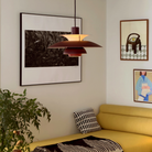 The PH 5 from Louis Poulsen in monochrome burgundy in a living room.