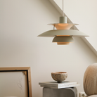The PH 5 from Louis Poulsen in monochrome pale pewter in a living room turned on.