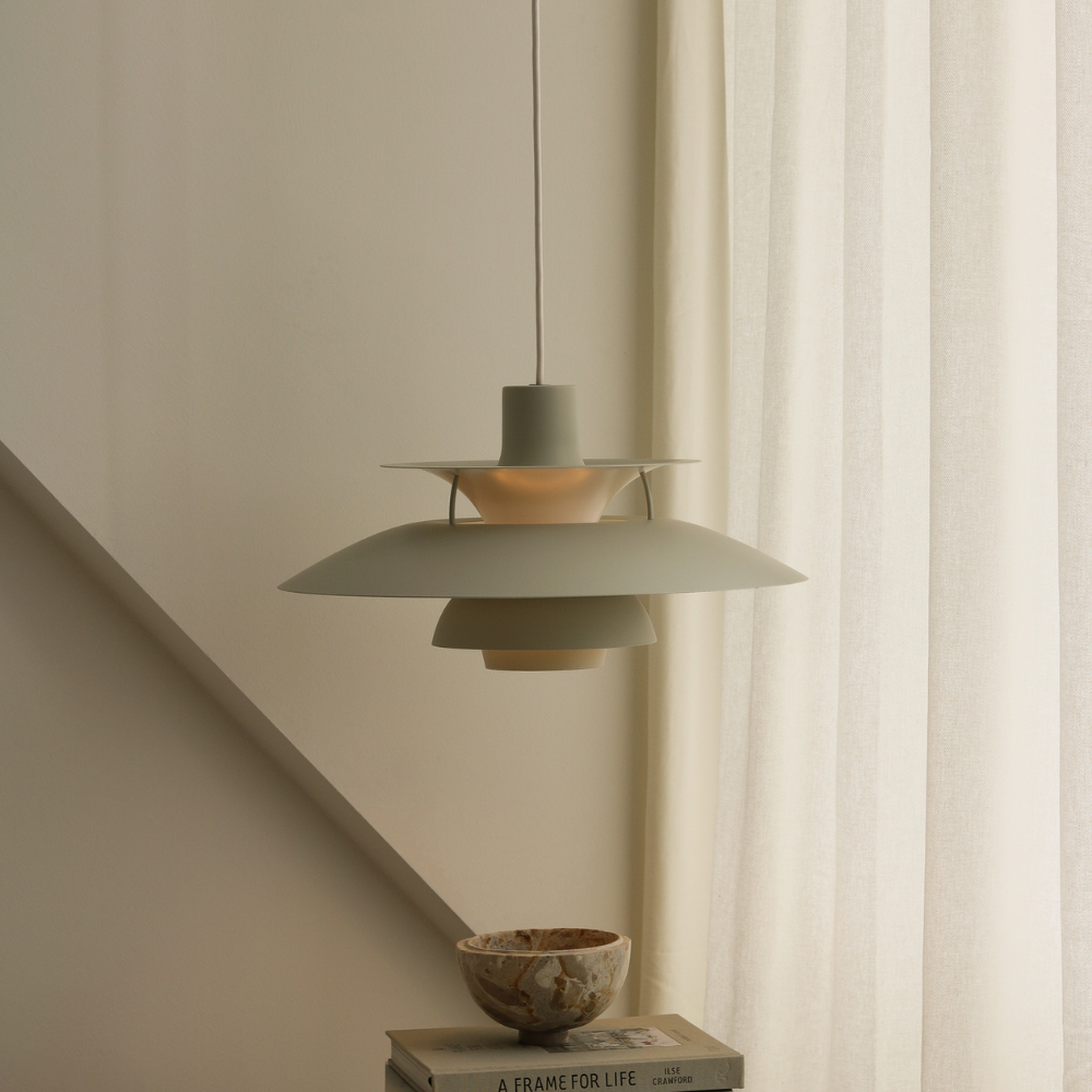The PH 5 from Louis Poulsen in monochrome pale pewter in a living room turned off.