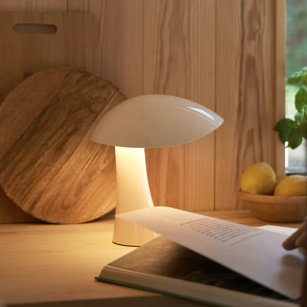Rumee 220 Portable Lamp in Cloud White being used as a reading light.