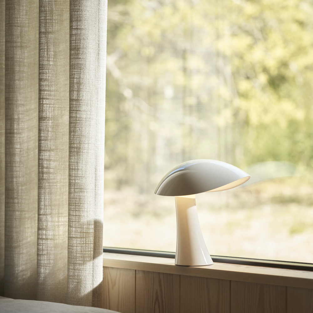 Rumee 220 Portable Lamp in Cloud White in a windowsill.