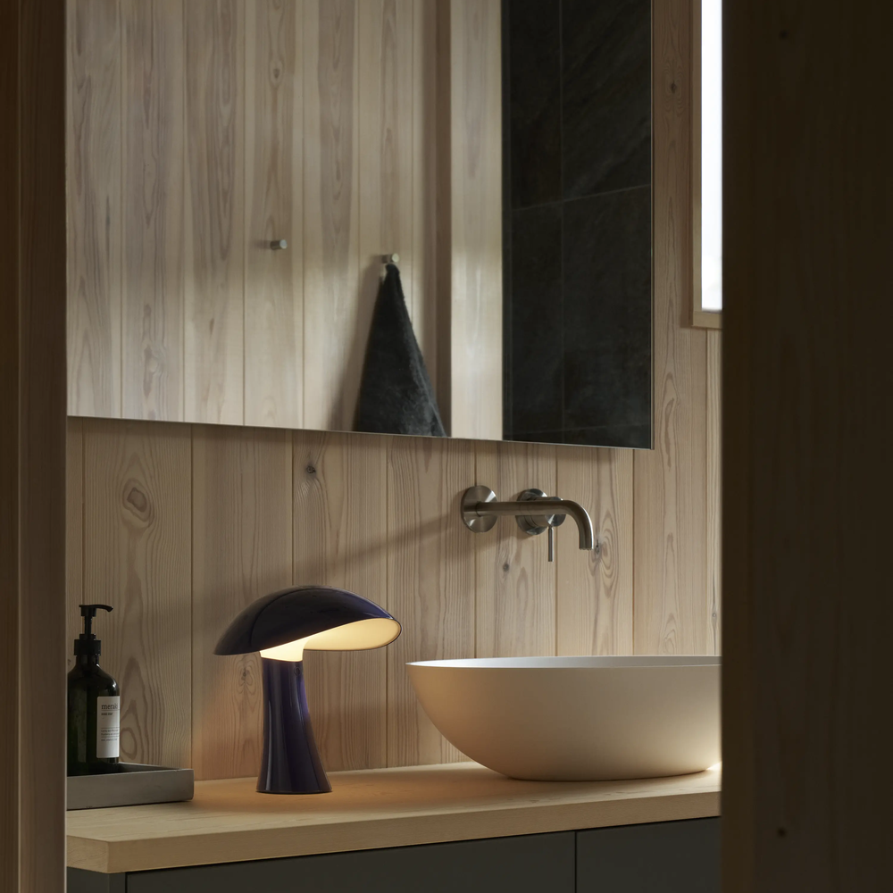 Rumee 220 Portable Lamp in Night Blue on a bathroom vanity counter.
