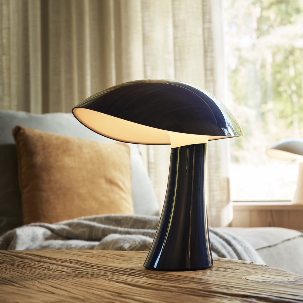 Rumee 220 Portable Lamp in Night Blue on a side table in a living room.