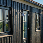 The Tolbod 6.1 Wall from Louis Poulsen outside a home.