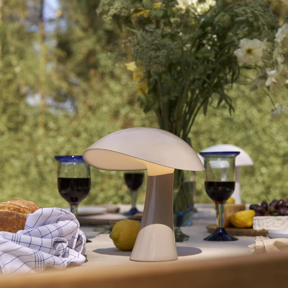 Rumee 220 Portable Lamp in Earth Grey on a table.