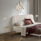 The Lita Pendant by Luceplan, 7-inch  pendants in matte white next to a bed.