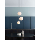 The Lita Pendant by Luceplan, 7-inch and 11.8 inch pendants in matte white over a dining table.