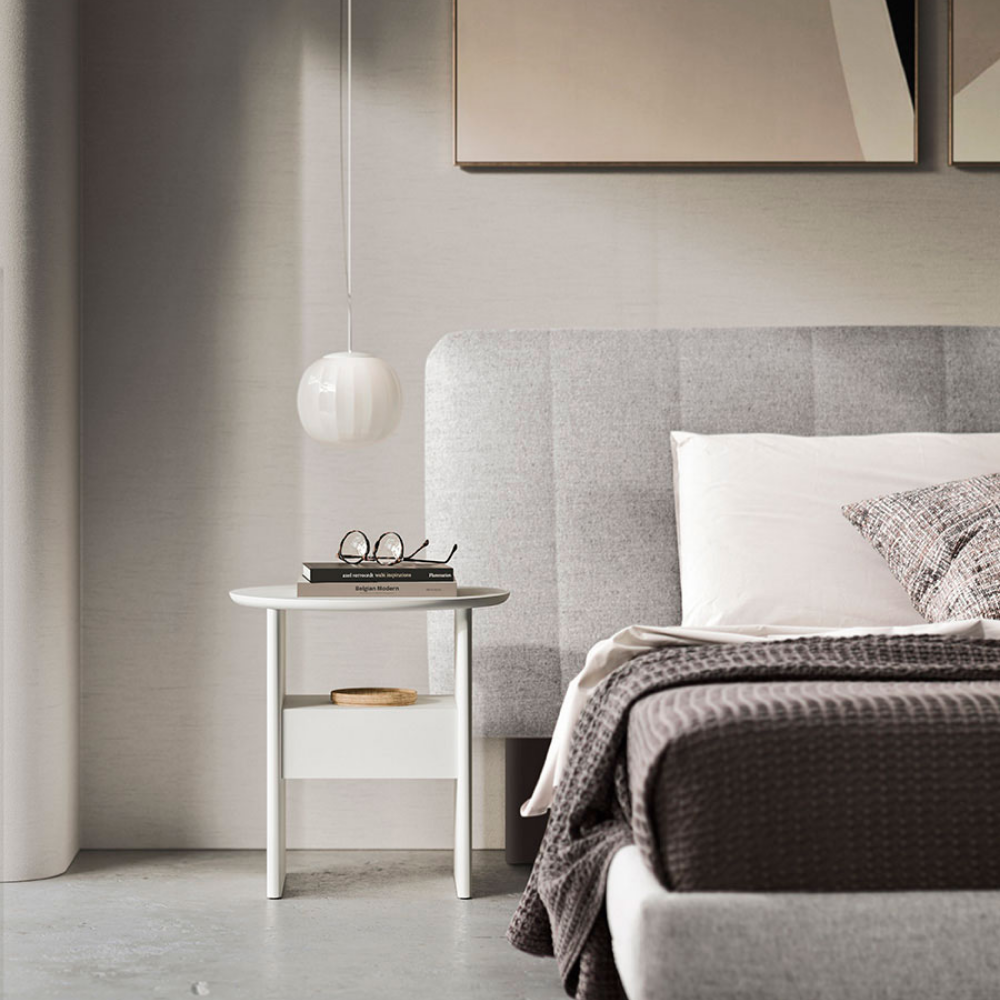 The Lita Pendant by Luceplan, 7-inch  pendants in matte white next to a bed.