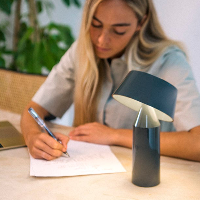 The Bicoca Portable Table Lamp from Marset in light blue in a family area.