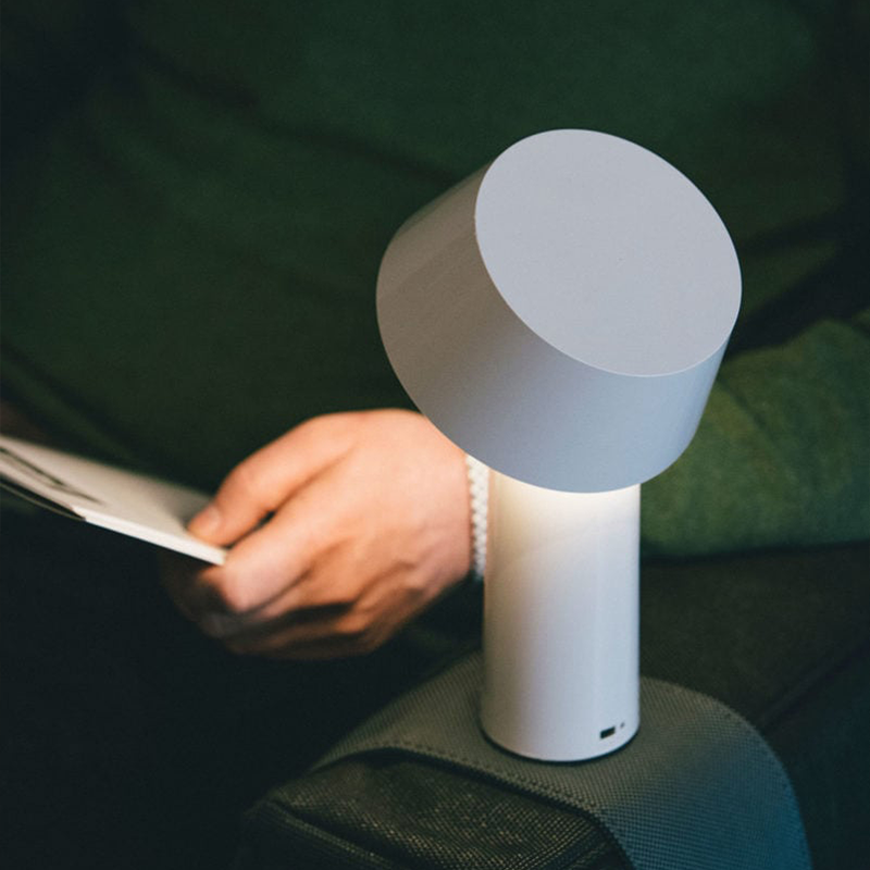 The Bicoca Portable Table Lamp from Marset in off-white in a family space.