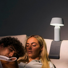 The Bicoca Portable Table Lamp from Marset in off-white in a primary bedroom.