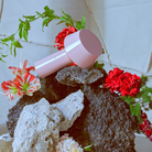 The Bicoca Portable Table Lamp from Marset in pale pink in a living space.