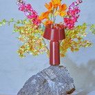 The Bicoca Portable Table Lamp from Marset in red wine in an outdoor dining space.