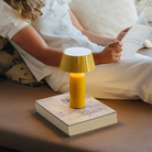 The Bicoca Portable Table Lamp from Marset in yellow in a guest bedroom.
