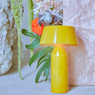 The Bicoca Portable Table Lamp from Marset in yellow in a guest room.