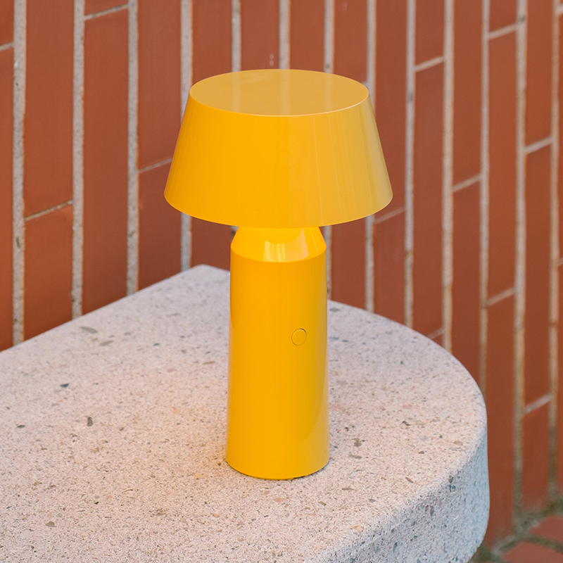 The Bicoca Portable Table Lamp from Marset in yellow in a home office.