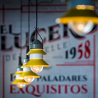 The Santorini Outdoor  Pendant from Marset in mustard within a restaurant.