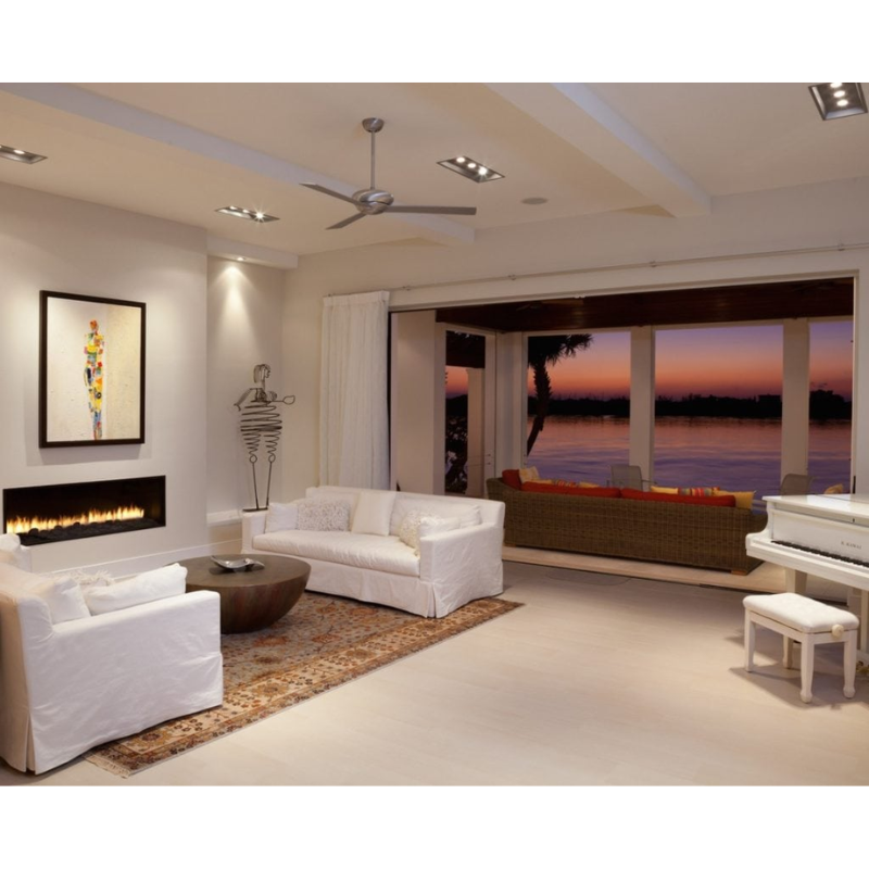 The Altus ceiling fan from The Modern Fan Co. in a living room of a beach house.