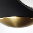The satin brass and matte black IC/Brisa DC - 56″ from Modern Fan Co. close up in a living space.