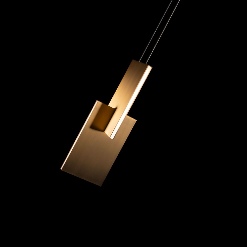 The aged brass Amari Pendant Light from Modern Forms in a bedroom.