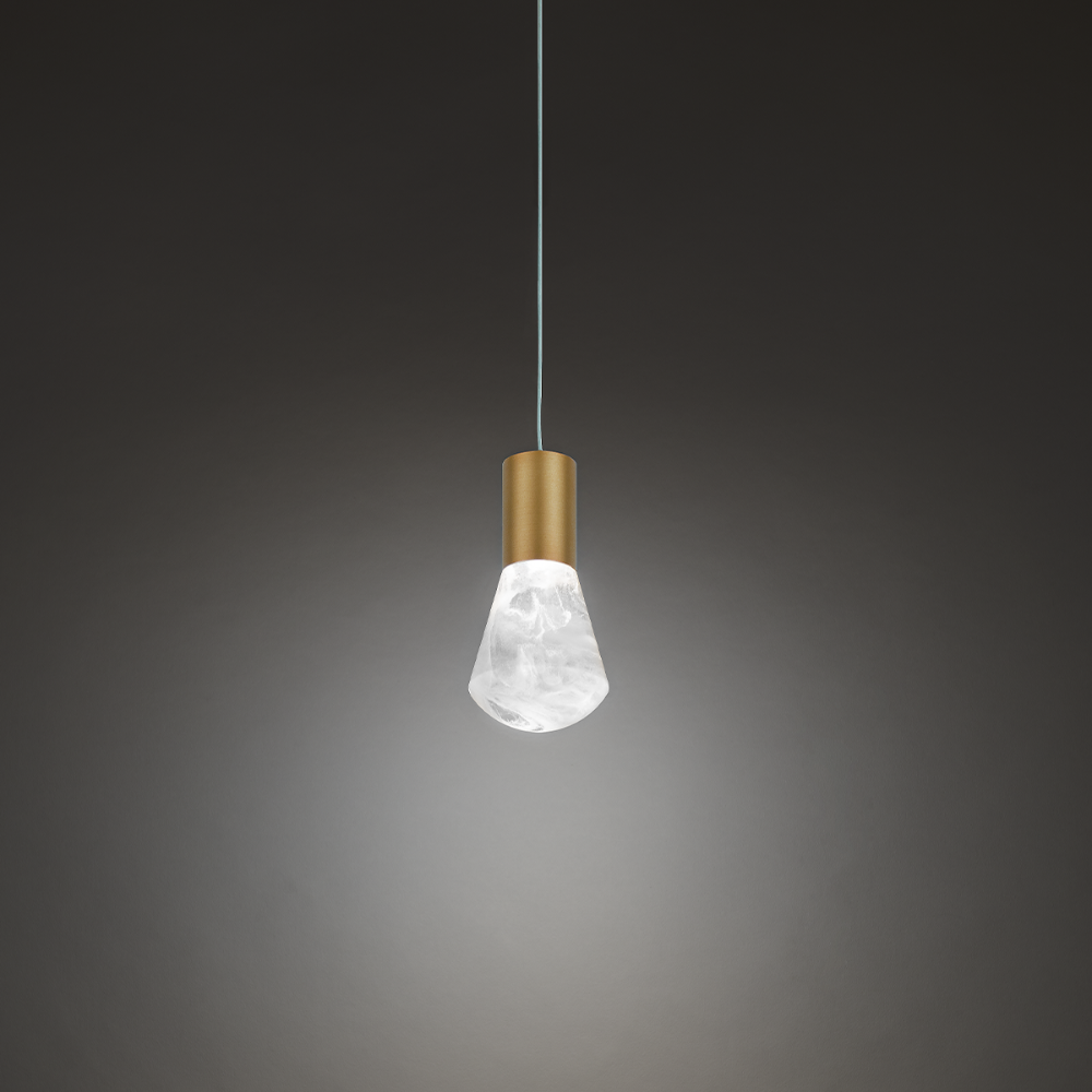 The aged brass Plum Pendant Light from Modern Forms in a studio.