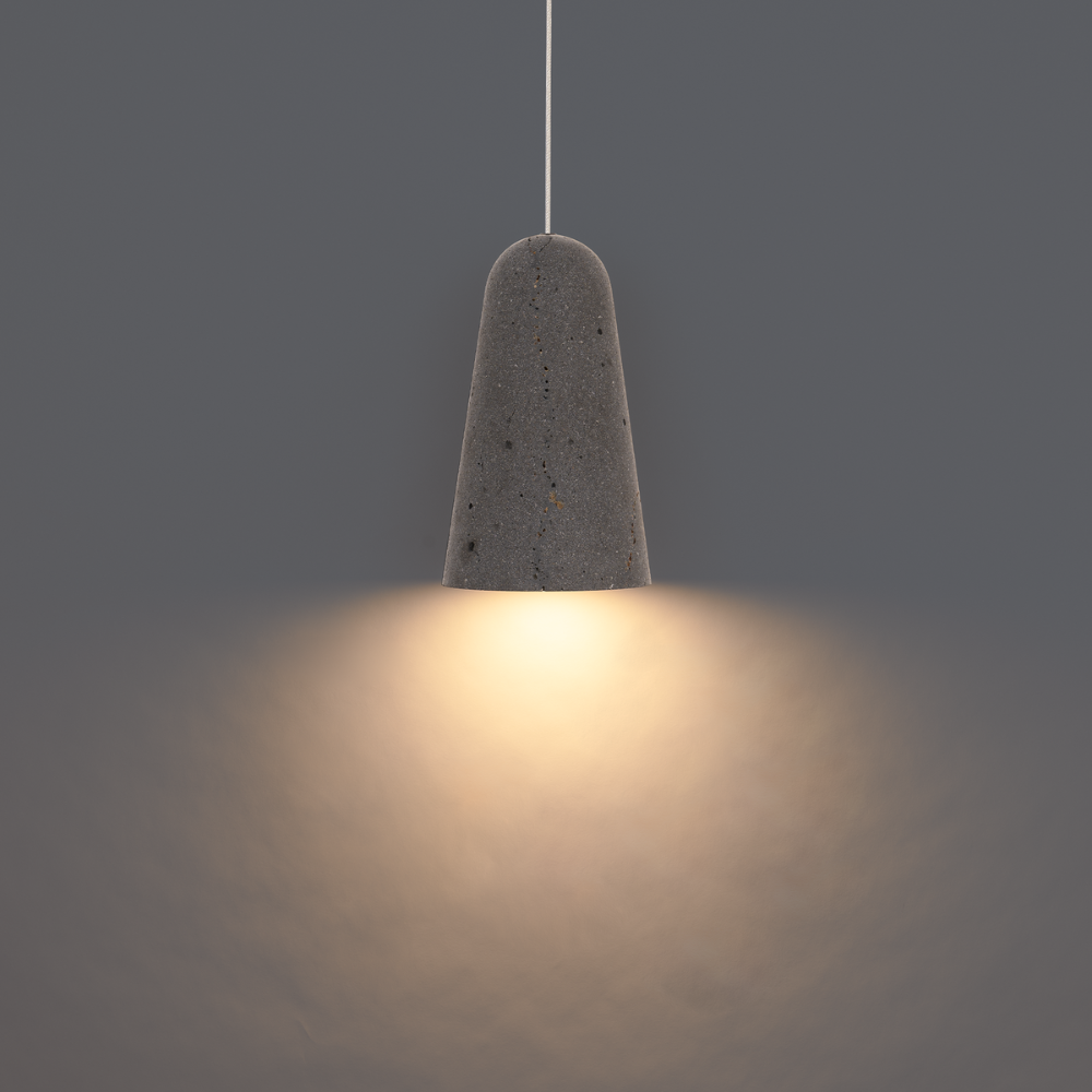 The basalt stone and black Pompeii Pendant Light from Modern Forms in a studio.