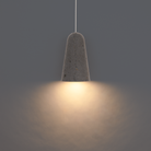 The basalt stone and black Pompeii Pendant Light from Modern Forms in a studio.