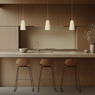 The beige travertine and aged brass Pompeii Pendant Light from Modern Forms above a kitchen island.