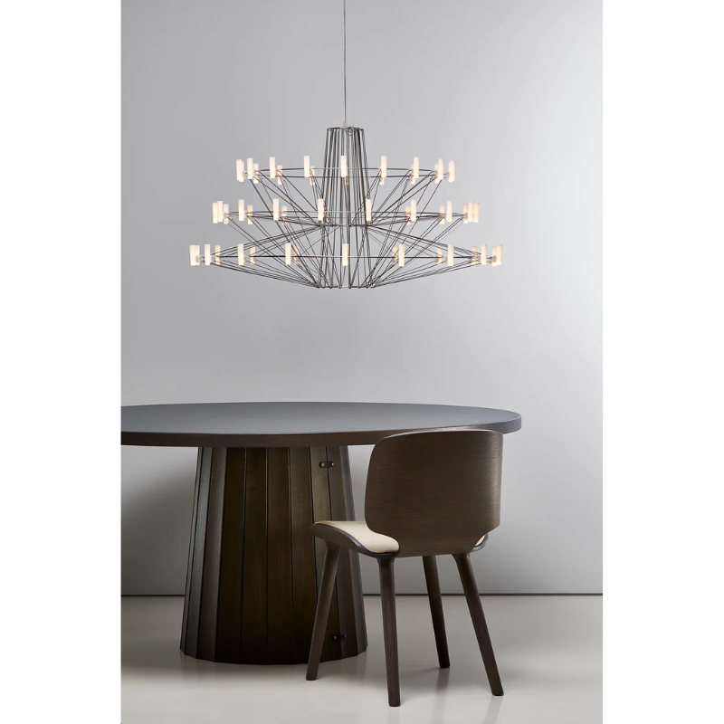 The Coppélia Suspended from Moooi above a dining table in a dining space.