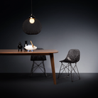 The Non Random Pendant by Moooi in black over a dining room table.
