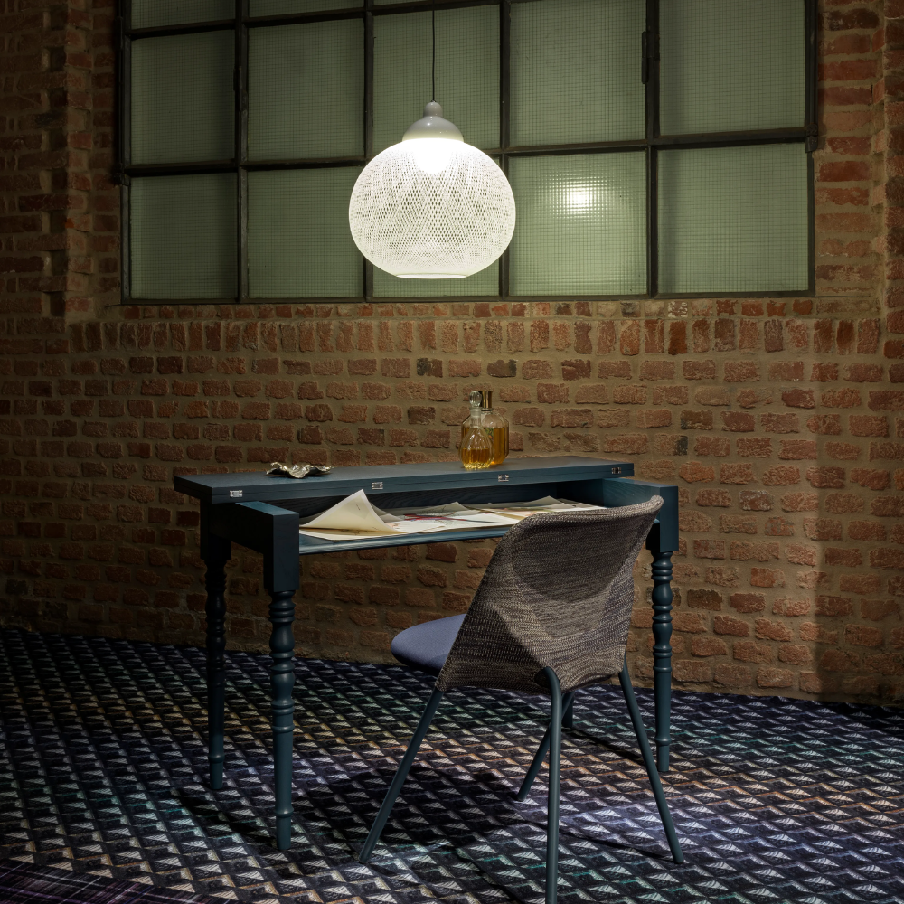 The Non Random Pendant by Moooi in white over a desk.