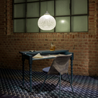 The Non Random Pendant by Moooi in white over a desk.