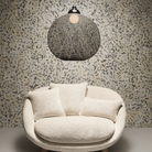The Non Random Pendant by Moooi in black over a lounge chair.