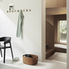 Muuto Attach Wall Hook in Oak in an entryway being used as a coat hanger. all-groups