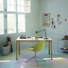 The brown green Dedicate Table Lamp from Muuto in an art studio.