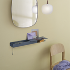 Folded shelf with platform tray blue grey in a bedroom.