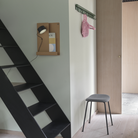 The 11 inch Folded Shelves from Muuto in Burnt Orange near the ladders in a hallway.