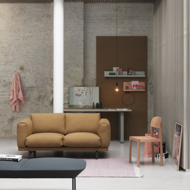 The Folded Shelves from Muuto in grey and burnt orange in a living room.