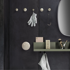 Muuto Folded wall Shelf in Olive green in a bedroom.