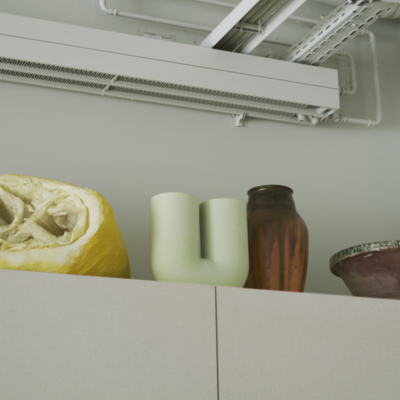 The Kink Vase Light Green from Muuto in a living room.