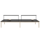 The Linear Mounted Lamp Black from Muuto is mounted on the table. all-groups