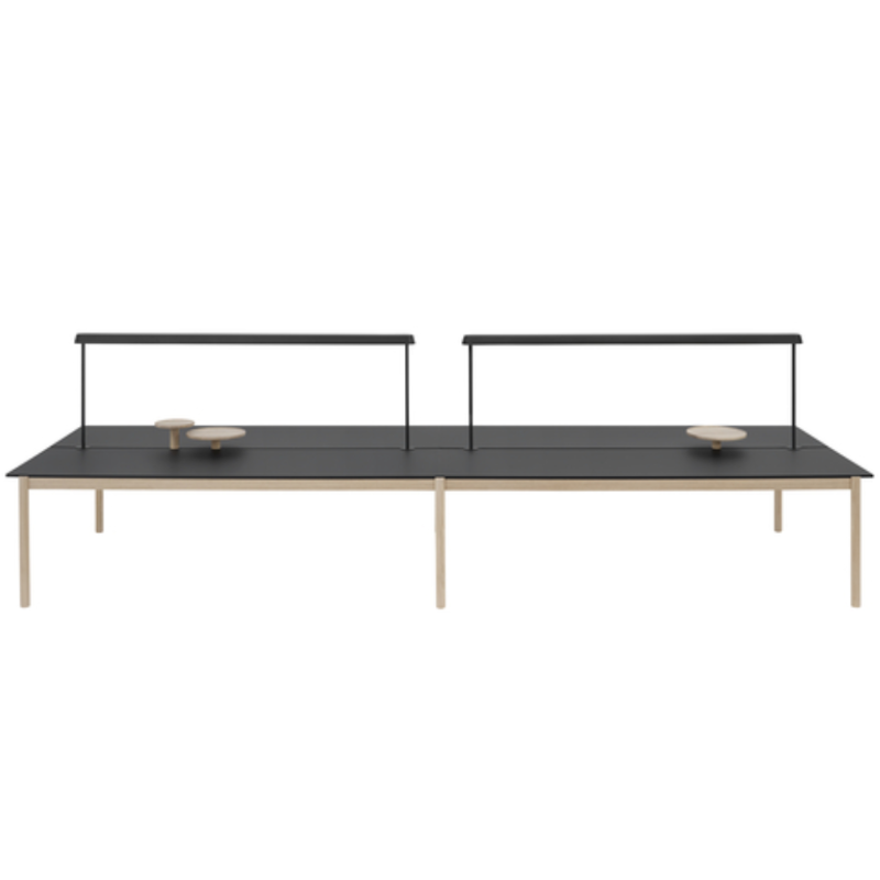 The Linear Mounted Lamp Black from Muuto is mounted on the table. all-groups
