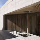 The dark green Linear Steel Bench from Muuto in an outdoor lounge.
