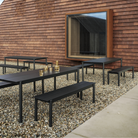 The black Linear Steel Table from Muuto in an outdoor restaurant space.