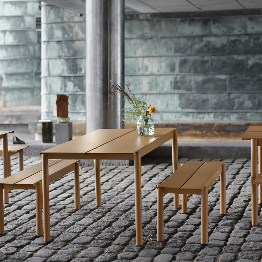 The burnt orange Linear Steel Table from Muuto used in an outdoor cafe.