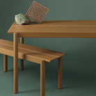The burnt orange Linear Steel Table from Muuto in a studio.