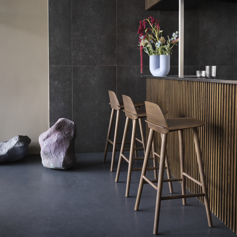 The stained dark brown Nerd Bar Stool from Muuto in a dining area.